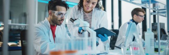 Modern Medical Research Laboratory: Portrait of Latin and Black Young Scientists Using Microscope, Digital Tablet, Doing Sample Analysis, Talking. Diverse Team of Specialists work in Advanced Lab